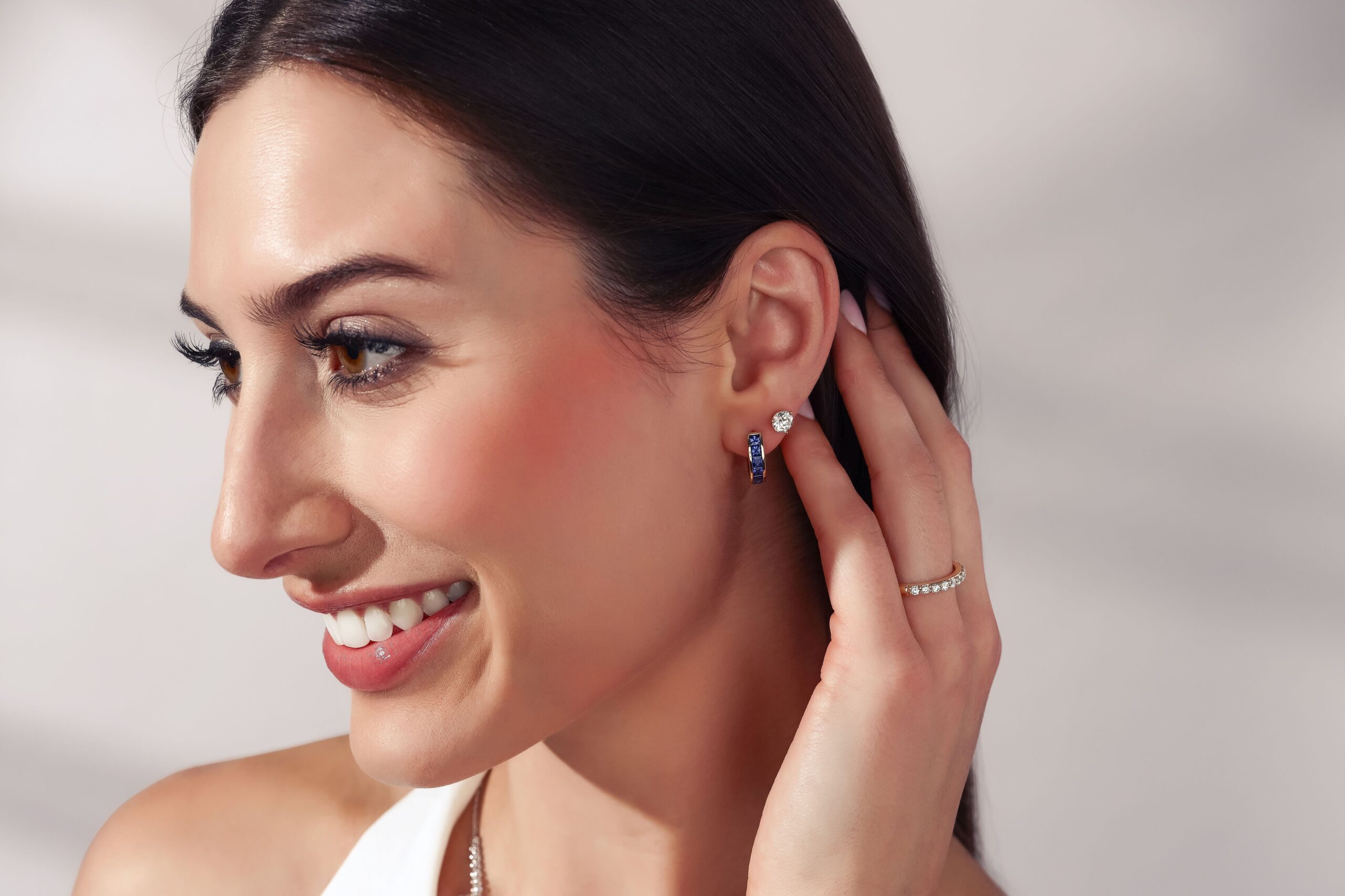 Sapphire hoop and diamond earring stack on female model