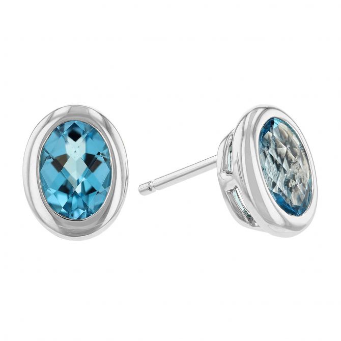 Oval Blue Topaz Bezel Set Stud Earrings in White Gold